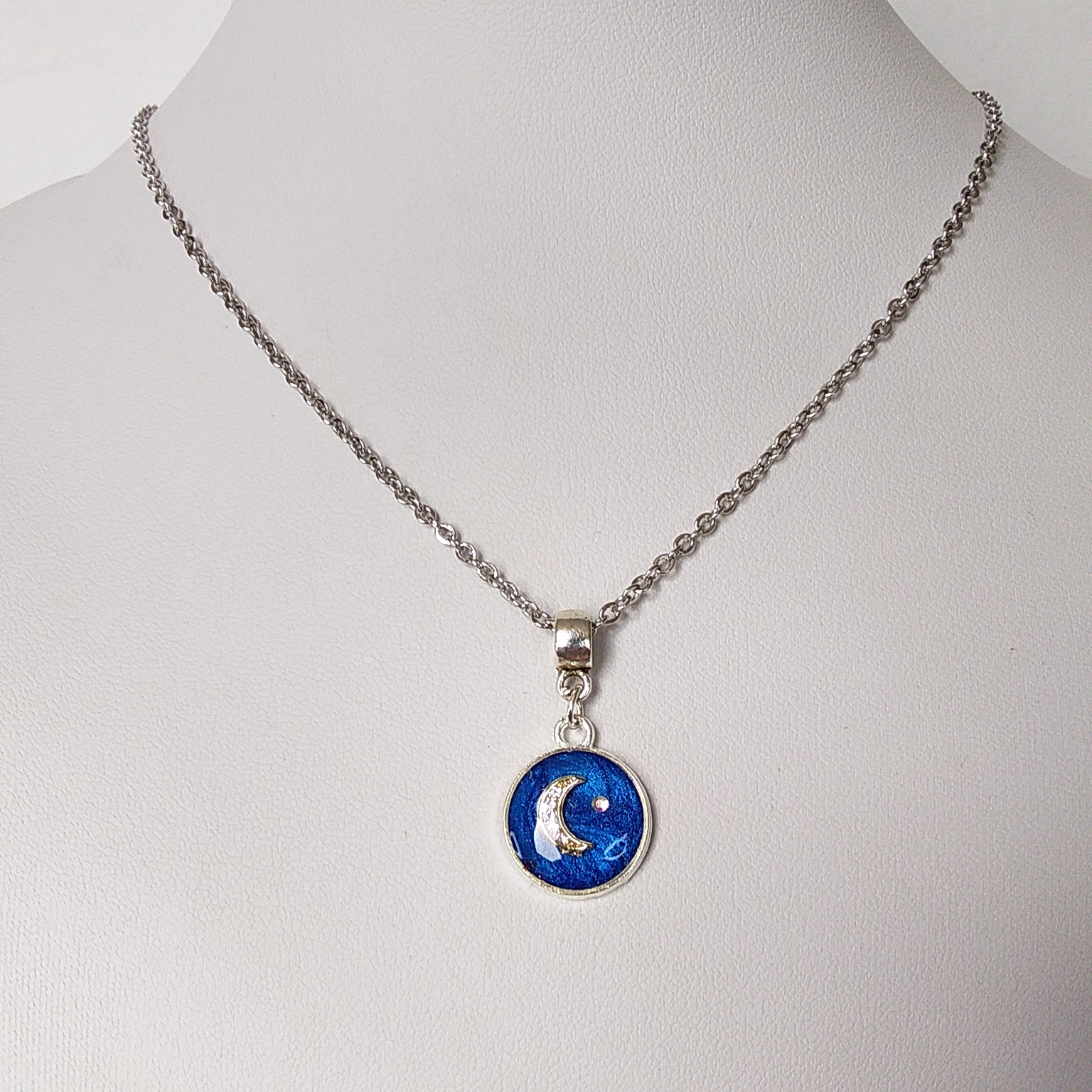 Collar Minimalista Luna Micropavé y cristal swarovski en fondo Azul